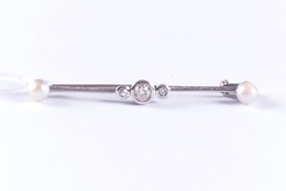 Broche en platine.
Sertie de deux perles...