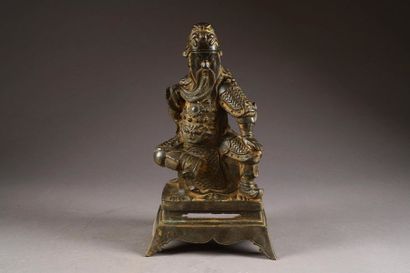 Kouan-ti assis. La jambe droite repliée,...