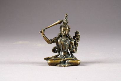 Manjushri assis en vajrasana. La main droite...