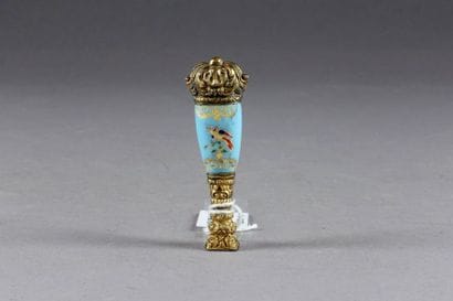 Cachet. Métal doré. Prise en porcelaine émaillée...