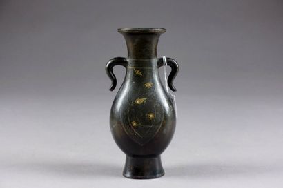 Vase balustre. Anses sinueuses. Bronze patiné...