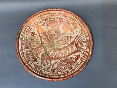 Plat en faience lustré à décor d'un oiseau...