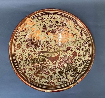 Plat en faience lustré à décor d'un oiseau...