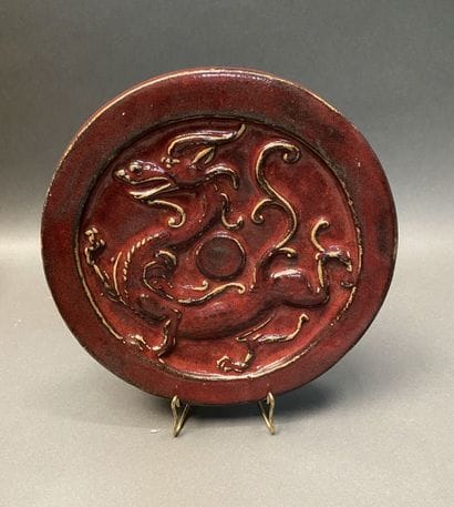 Plat en grès émaillé rouge à décor d'un dragon...