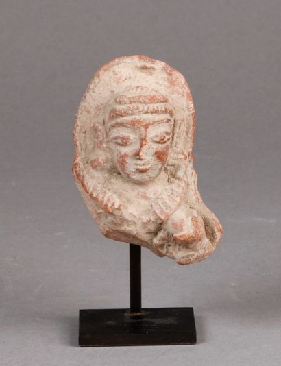 TÊTE de femme parée de bijoux en terre cuite.
Art...