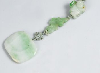 COLLIER composé de quatre perles de jadéite...