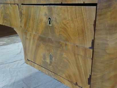Bureau plat en placage d'acajou ouvrant à...