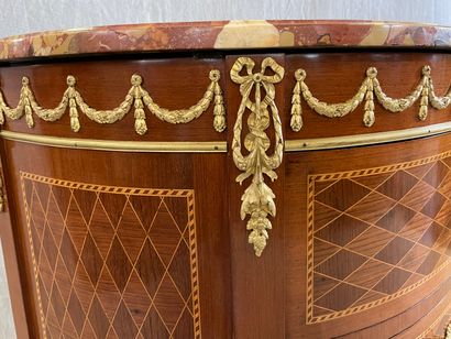 Commode demi-lune en marqueterie et bronzes.

Style...