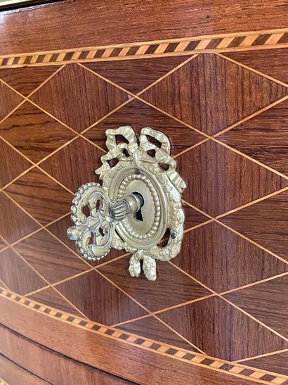 Commode demi-lune en marqueterie et bronzes.

Style...