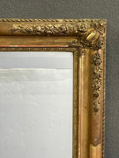 Miroir cadre en bois et stuc doré à décor...