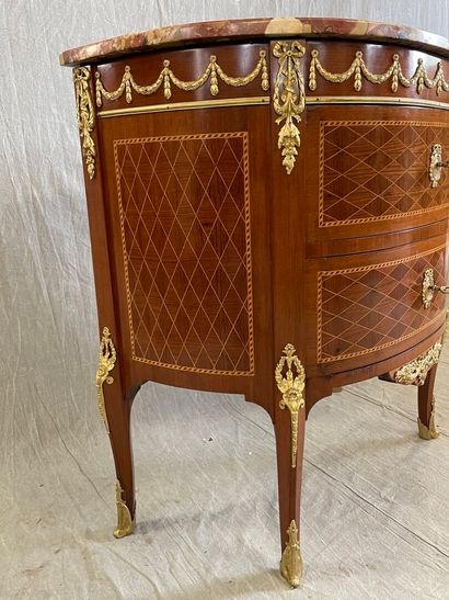 Commode demi-lune en marqueterie et bronzes.

Style...