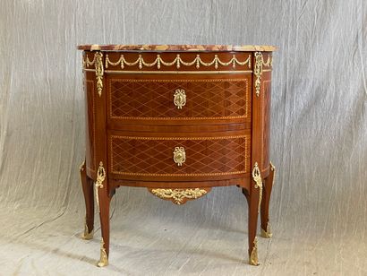 Commode demi-lune en marqueterie et bronzes.

Style...