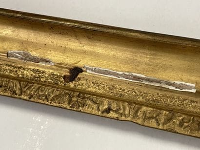 Cadre en bois et stuc doré, surmonté de deux...