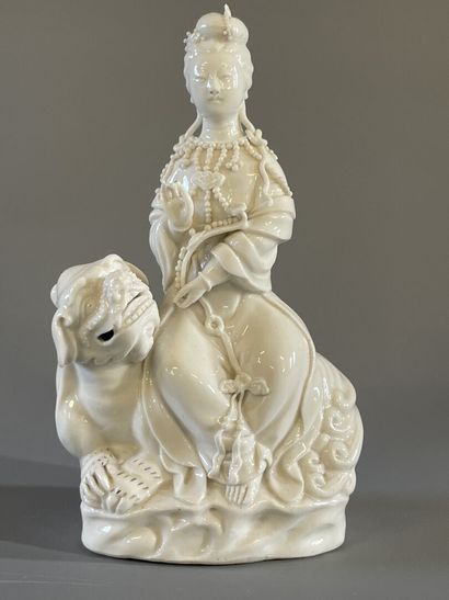 Guan Yin assise sur un chien de fo en porcelaine...