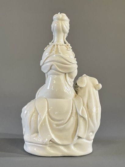 Guan Yin assise sur un chien de fo en porcelaine...