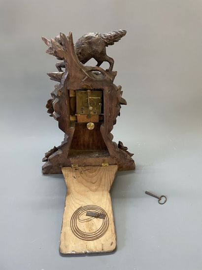 Importante pendule en bois sculpté figurant...
