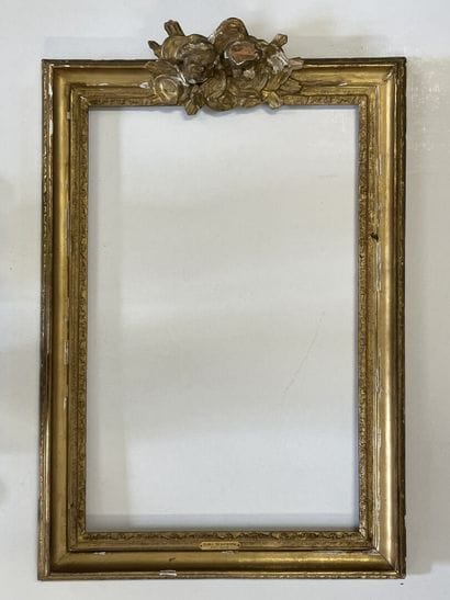 Cadre en bois et stuc doré, surmonté de deux...