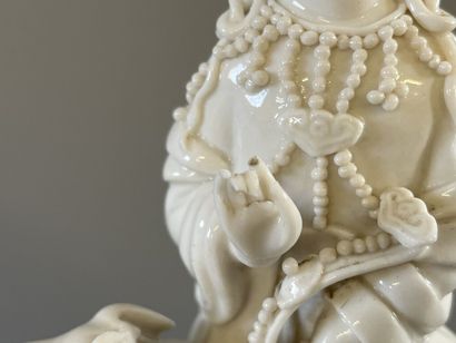 Guan Yin assise sur un chien de fo en porcelaine...