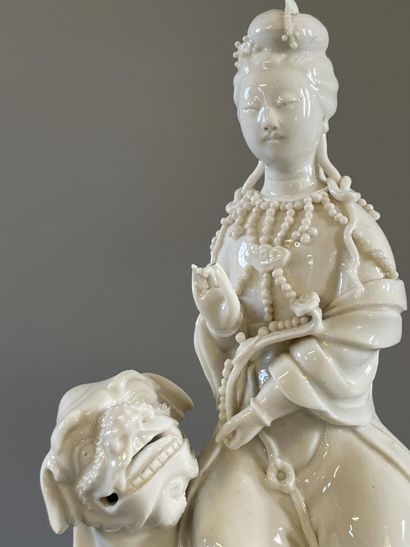 Guan Yin assise sur un chien de fo en porcelaine...