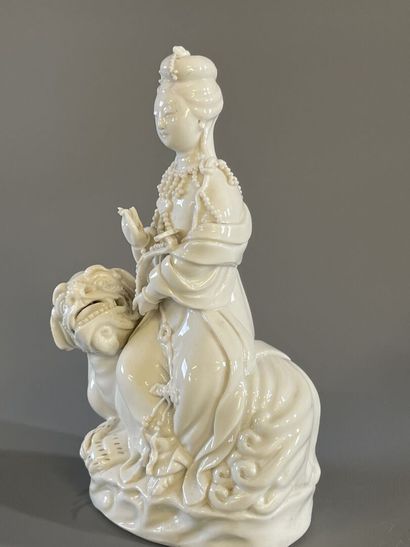 Guan Yin assise sur un chien de fo en porcelaine...
