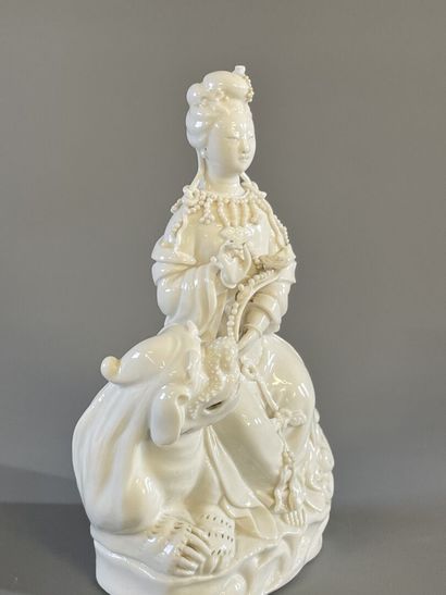 Guan Yin assise sur un chien de fo en porcelaine...