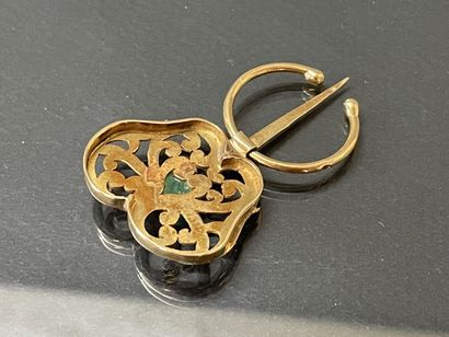 Gold fibula set with an emerald in a green...