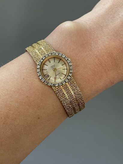 Lady's watch in gold, round dial, surrounded...