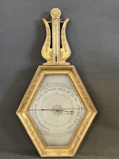 Baromètre en bois doré surmonté d'une lyre.

Epoque...