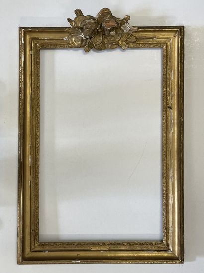 Cadre en bois et stuc doré, surmonté de deux...