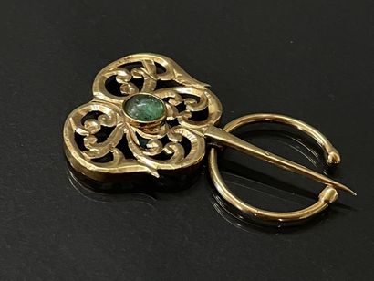Gold fibula set with an emerald in a green...