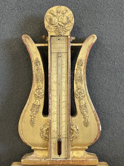 Baromètre en bois doré surmonté d'une lyre.

Epoque...