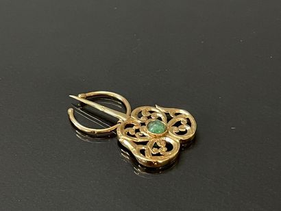 Gold fibula set with an emerald in a green...