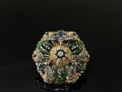 A circular pendant brooch depicting a flower...