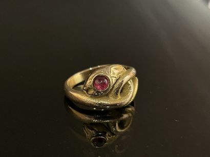 Gold snake ring with a small ruby in a closed...