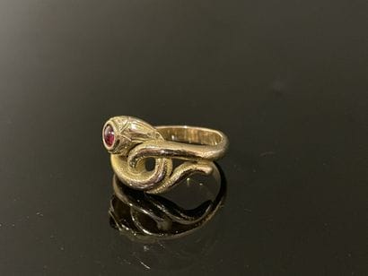 Gold snake ring with a small ruby in a closed...