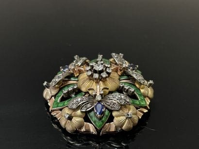 A circular pendant brooch depicting a flower...