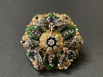A circular pendant brooch depicting a flower...