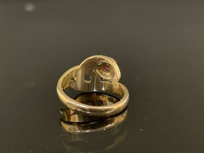 Gold snake ring with a small ruby in a closed...