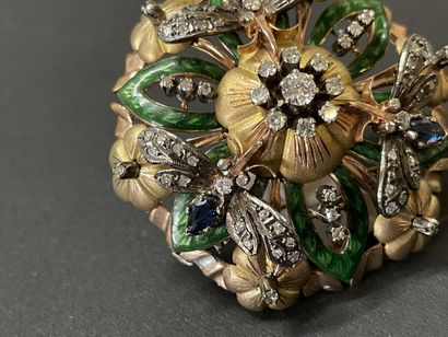 A circular pendant brooch depicting a flower...