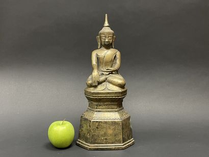 Ancient Buddha seated in majesty on a lotus-decorated...