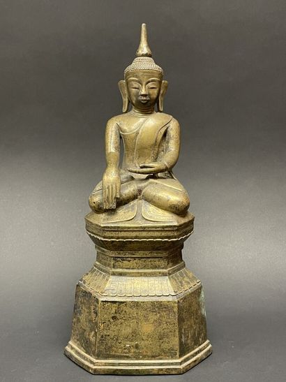 Ancient Buddha seated in majesty on a lotus-decorated...