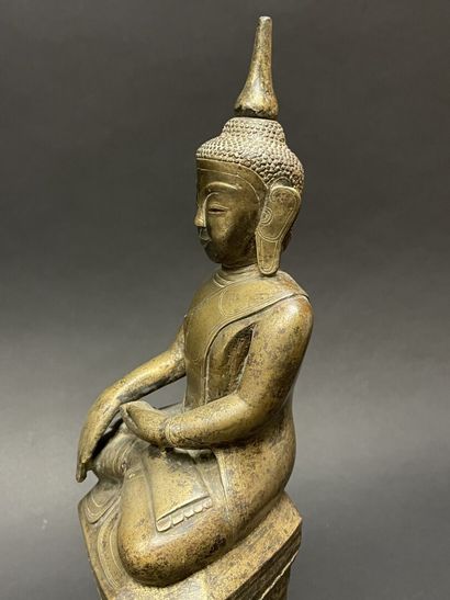 Ancient Buddha seated in majesty on a lotus-decorated...