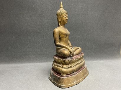 Buddha seated in virasana on a plinth adorned...