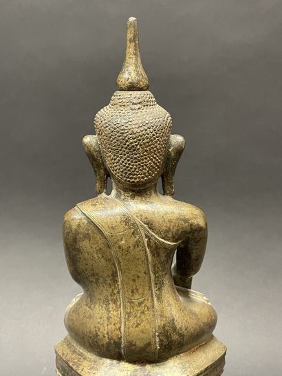Ancient Buddha seated in majesty on a lotus-decorated...