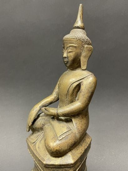 Ancient Buddha seated in majesty on a lotus-decorated...