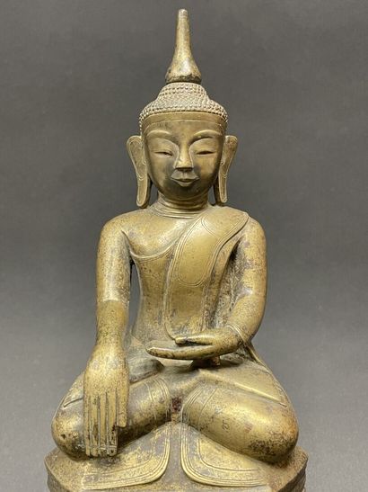 Ancient Buddha seated in majesty on a lotus-decorated...