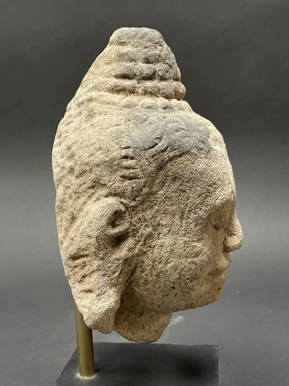 An ancient head of a mucalinda Buddha, smiling...