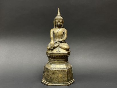 Ancient Buddha seated in majesty on a lotus-decorated...