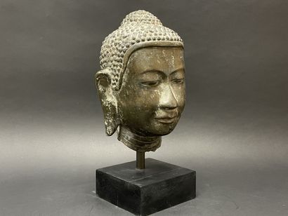 Tête de Bouddha au doux sourire, yeux mi-clos....
