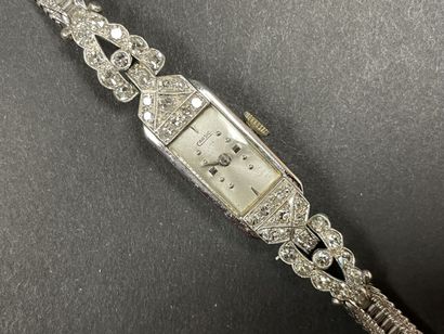 Montre de dame en or, pavage de petits diamants.
Art...